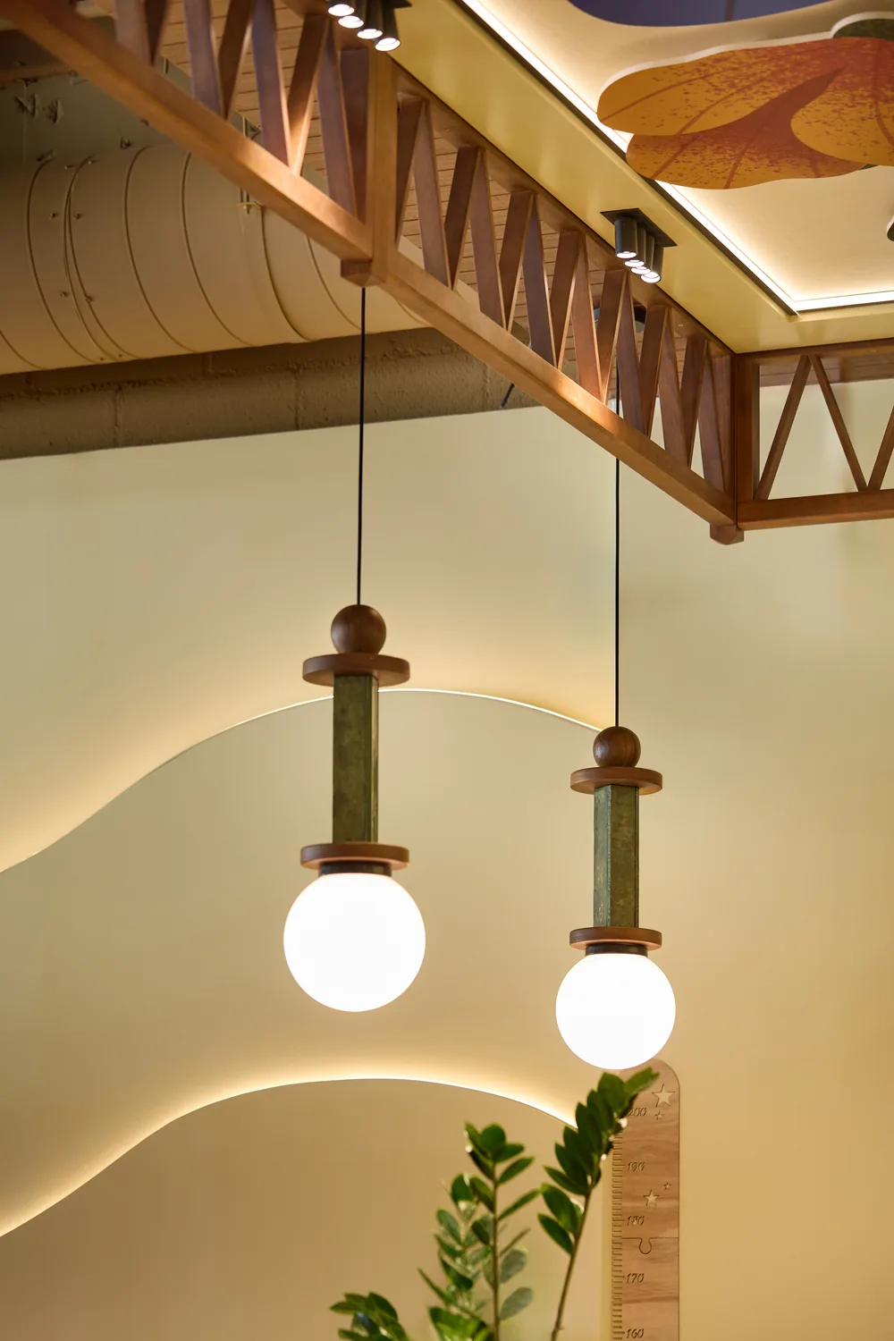 Lámparas colgantes de madera y vidrio sobre la pared ondulada iluminada